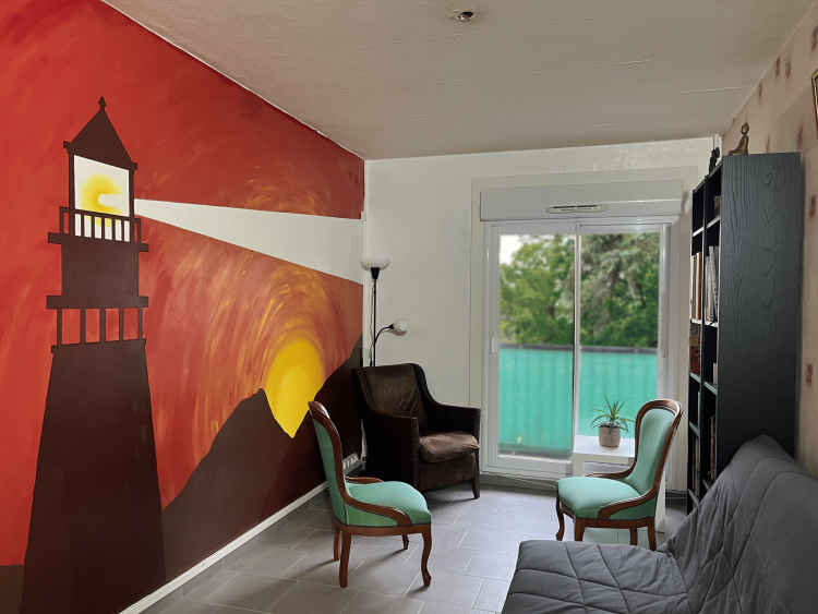 Photographie du cabinet de Vincent Morfoisse. On y voit une fresque représentant un phare peinte sur le mur et trois fauteuils près de la fenêtre.